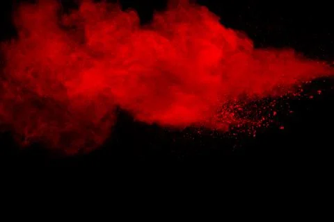 Red particles explosion on black background. Freeze motion of red dust splash Foto stock