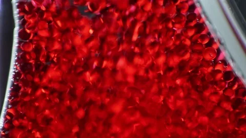 Red particles flowing into fluid Stock Footage 101484725