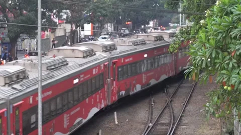 Red Passenger Train Moving Along City Railway Line in Bandung Video stock 343136589