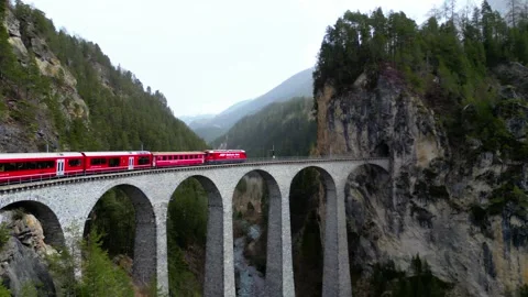 Red Passenger Train Moving Through Swiss Mountains Drone Aerial Vídeo Stock 339104640
