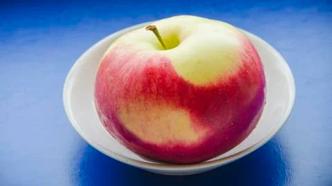 Red patterned apple on a blue background Stock Photos
