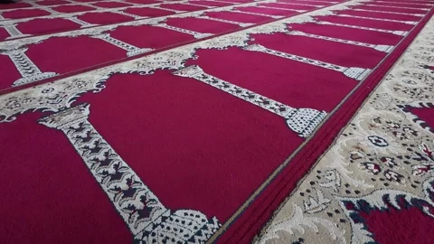 Red patterned mosque prayer carpet viewed from low perspective Video stock 342582470