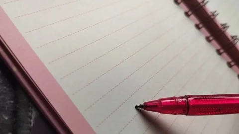 Red pen tapping notebook showing mental block Stock Footage 323528170