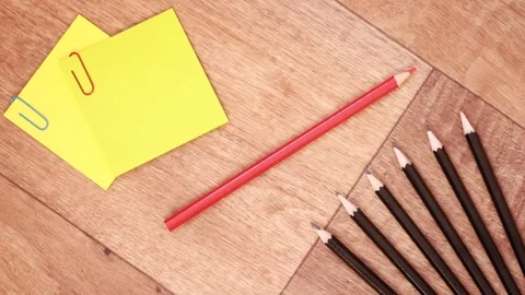 Red pencil between black pencils and colorful stickers Видео 99954940