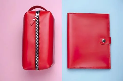 Red pencil case and notebook on pastel pink and blue background Stock Photos