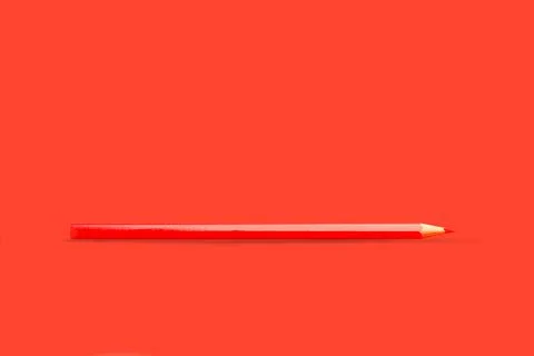 Red pencil on a red background with copy space Foto stock
