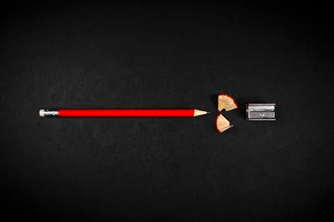 Red pencil with sharpener on a dark background. Stock Photos