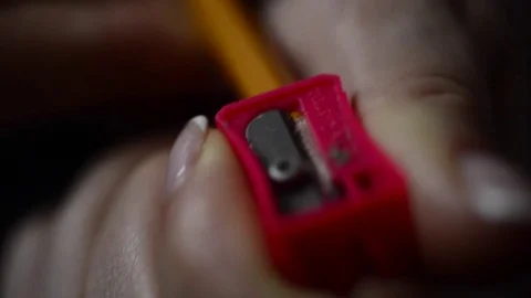 Red pencil sharpener in a woman's hand sharpening a pencil, macro 動画素材 74378829