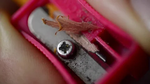 Red pencil sharpener in a woman's hand sharpening a pencil, macro Video stock 74378971