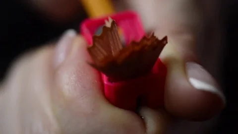 Red pencil sharpener in a woman's hand sharpening a pencil, macro Video stock 74379001