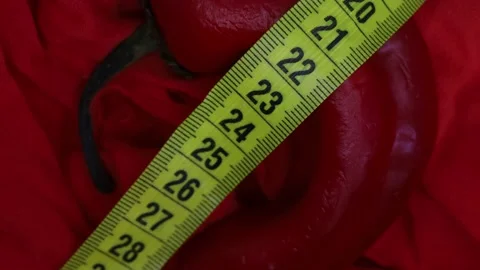 Red pepper and measuring tape on red fabric background Stock Footage 185598302