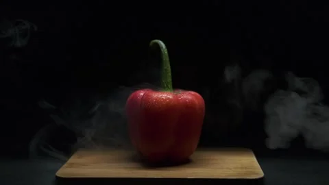 Red pepper on a black background, There is smoke in the frame. Video stock 300678187