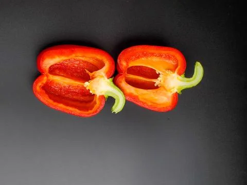 Red pepper cut in half, isolated on a black background Stock Photos