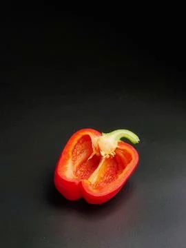 Red pepper cut in half, isolated on a black background Stock Photos
