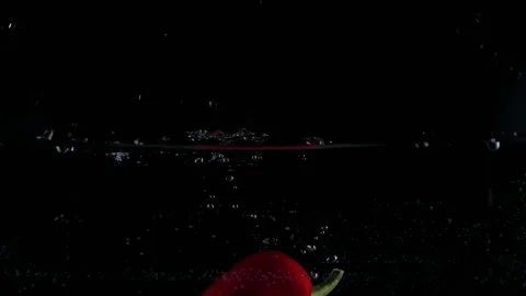 Red pepper dropped falling in water with lot of splashes Stock Footage 148736758