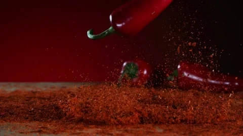 A red pepper drops into a pile of red spice powder Stock Footage 326628239