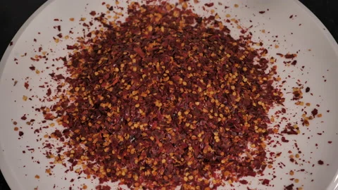Red pepper flakes are poured onto platter, overhead shot. Stock Footage 140267370