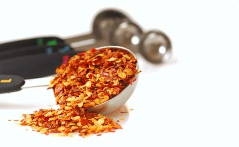 Red pepper flakes in a measuring spoon Stock Photos