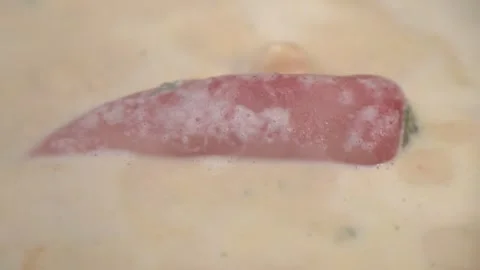 Red pepper floating in creamy boiling soup close-up 스톡 동영상 320756870