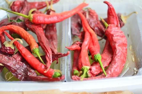 Red pepper on a light background lie in a box dry a large amount of 库存照片