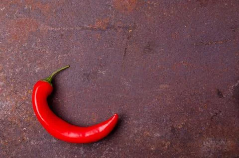 Red pepper pod on a rusty brown metal background. Stock Photos