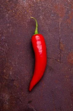 Red pepper pod on a rusty brown metal background. Stock Photos