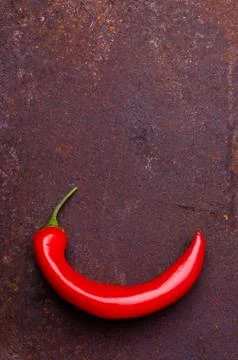 Red pepper pod on a rusty brown metal background. Stock Photos
