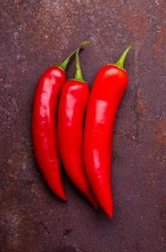 Red pepper pod on a rusty brown metal background. Stock Photos