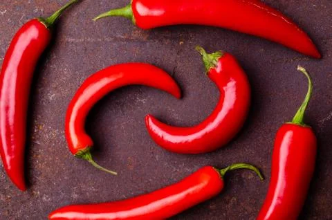 Red pepper pod on a rusty brown metal background. Stock Photos