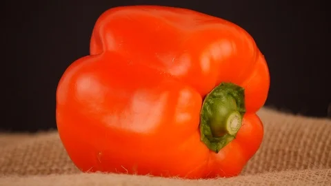 A red pepper on a rotating table. On a rustic background Stock-Footage 103457539