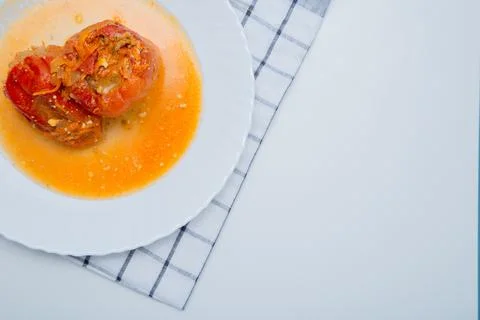 Red pepper stuffed with minced meat and carrots with onions lies on a white Stock Photos