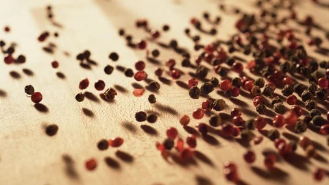 Red peppercorns falling and rolling on a table. Slow Motion. Stock Footage 128952130
