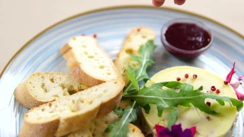 Red peppercorns, pate and small croutons, sprinkle with cherry sauce on a blue Stock Footage 320823469