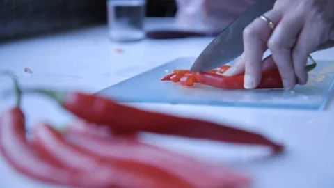 Red peppers being cut in background with red peppers in foreground Stock Footage 72559042