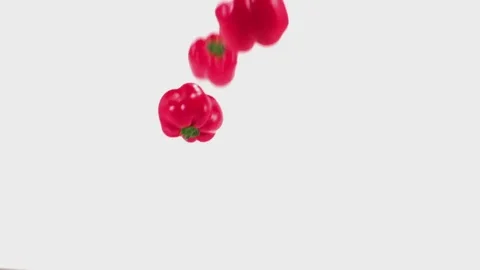 Red peppers fall onto a white cyc in slo mo Stock Footage 70681727