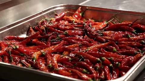 Red peppers get salt on a plate. Stock Footage 74479902
