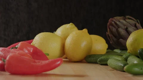 Red peppers lemon cucumber and artichoke on black background Stock Footage 274647751