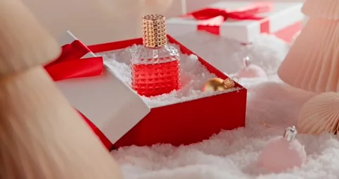 Red perfume rests inside a lovely Christmas gift box. Vídeo Stock 346053028