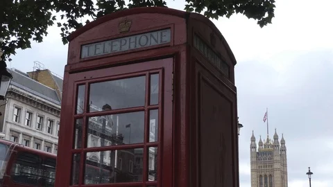 Red phone booth and ancient tower. Stock Footage 79940854