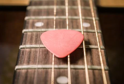 Red Pick on Acoustic Guitar String in Vintage Tone Stock Photos