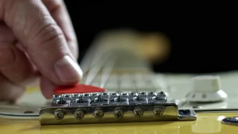 A red pick on the strings of an electric guitar close-up. Guitar fingerboard Vidéo 238951306