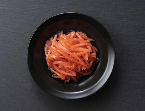 Red pickled ginger placed on a black background Stock Photos