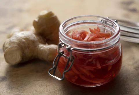 Red pickled ginger placed on an old wooden background. Stock Photos