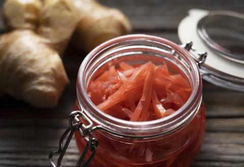 Red pickled ginger placed on an old wooden background. Stock Photos