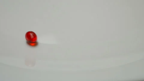 Red pill rotate, close up A single pill laid out on a white surface Stock Footage 86172790