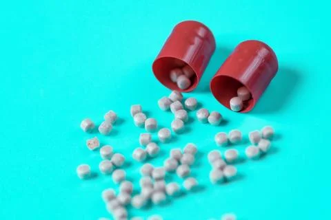 Red pills piled pellets on a blue background Stock Photos