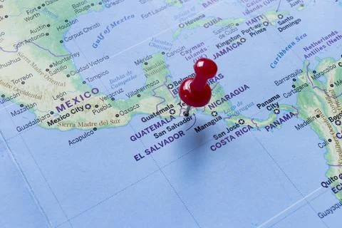 Red pin embroidered on the world map of El Salvador. Stock Photos