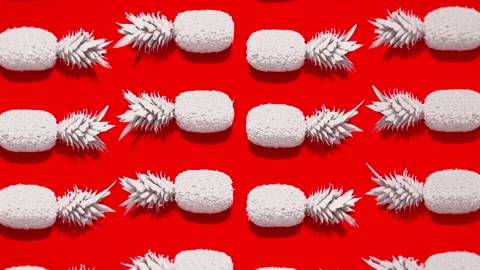 Red pineapples on red background as a summer background Stock Footage 237110257