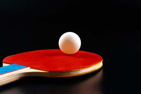 Red ping pong racket on dark background Stock Photos