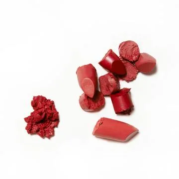 Red pink broken and smashed lipstick on white background Stock Photos